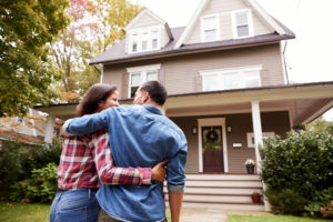 Couple standing in front of home.